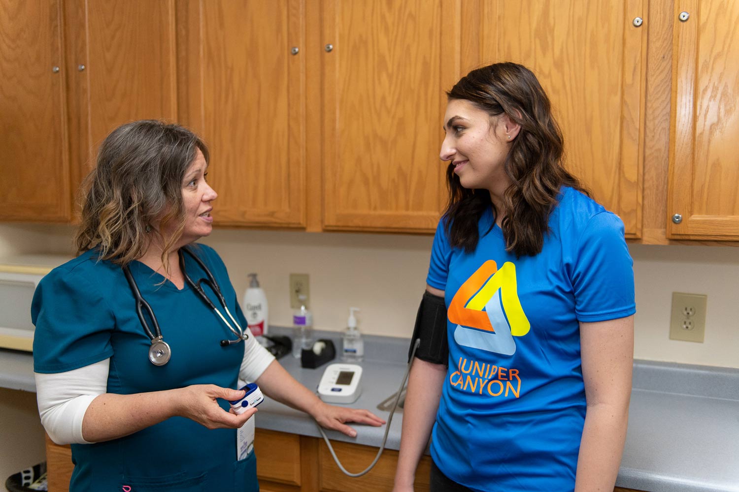 A nurse performs a comprehensive medical assessment for a new client, an essential first step in an integrated mental health treatment plan that addresses both physical and emotional well-being.