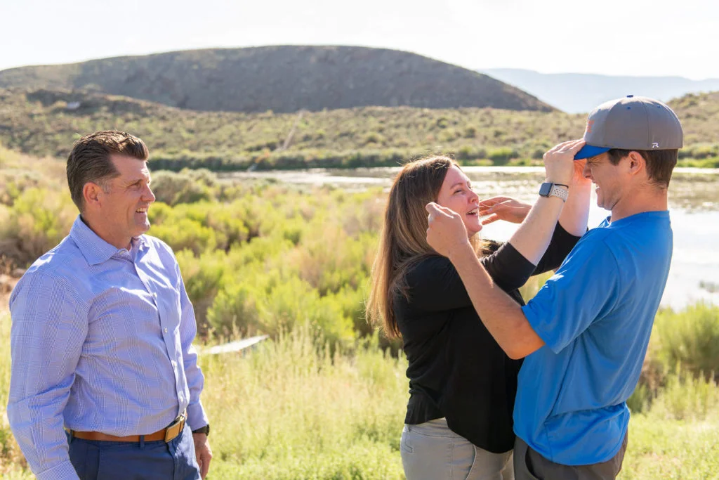 A young man and his parents share a joyful, laughing moment during a family therapy visit, showcasing a therapeutic approach that focuses on healing relationships and celebrating progress together.