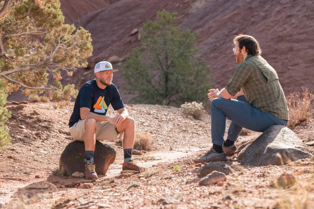 A therapist and a young man conduct a therapeutic assessment in a relaxed, outdoor setting, a nature-based approach that helps build rapport and encourage open communication.