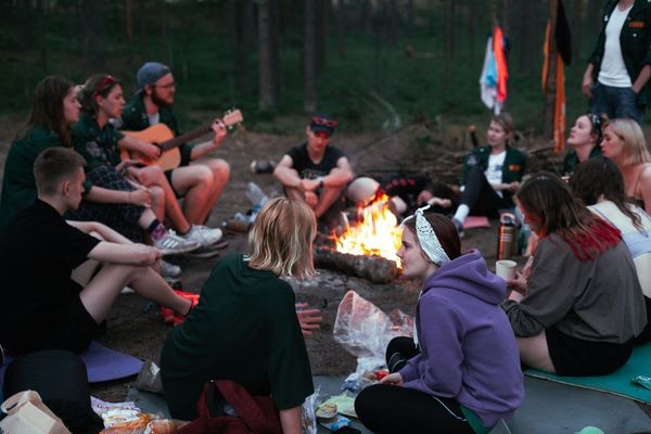 Clients participating in an evening campfire group with music, reflection, and peer connection during wilderness therapy at Legacy Outdoor Adventures.