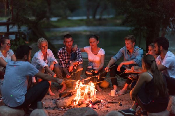 Clients sitting together around an evening campfire during a peer support and recovery discussion at Legacy Outdoor Adventures in Loa, Utah.