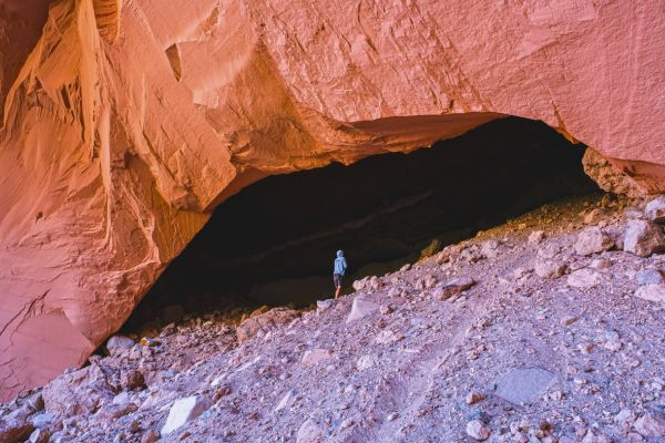 Client exploring a sandstone cave during an outdoor adventure at Legacy Outdoor Adventures' residential addiction treatment program.